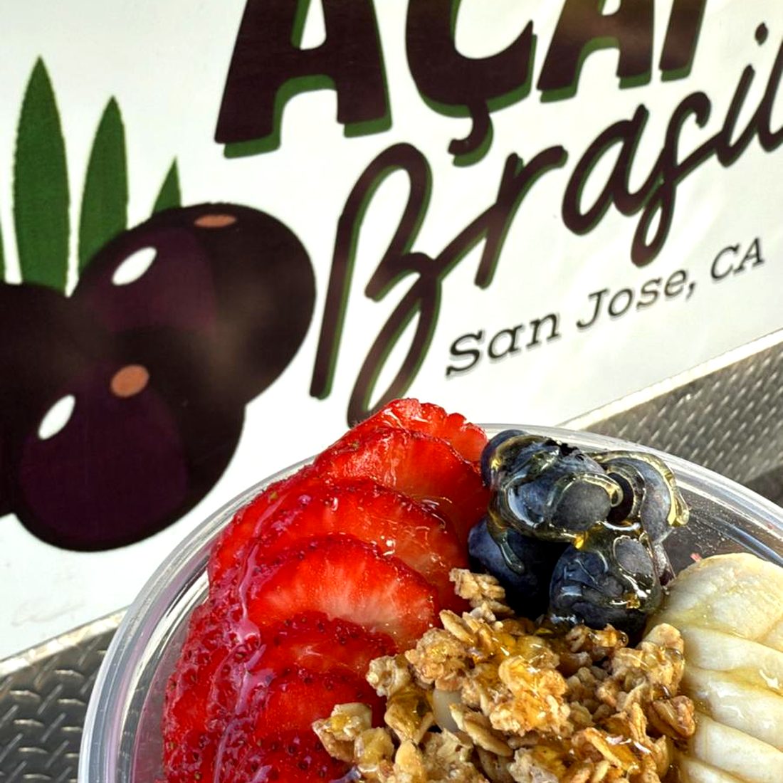 Açaí bowl in front of the Açaí Brasil SJ sign